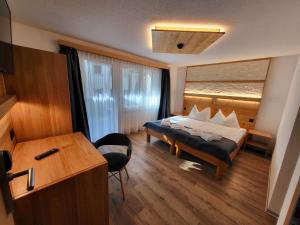 サースフェーにあるHotel Europaのベッドとデスクが備わるホテルルームです。