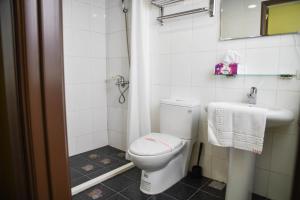 a bathroom with a toilet and a sink at Way Young House in Jiufen