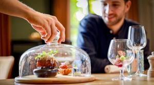 a person reaching for a miniature plant in a glass container at B&B T'Rest - Park ter Rijst in Heikruis