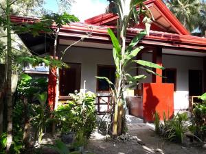 a house with a red roof and some plants at Bearby's Homestay Siargao - RH in Catangnan