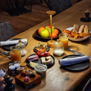 a table topped with plates of food and fruit at B&B T'Rest - Park ter Rijst in Heikruis