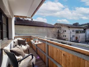 balcón con 2 sillas y vistas a un edificio en Alpine Homes - Hopfgarten, en Hopfgarten im Brixental