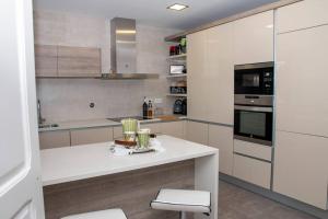 cocina con armarios blancos y encimera blanca en Beautiful cozy cottage near Nazaré, Leiria&Batalha en Juncal