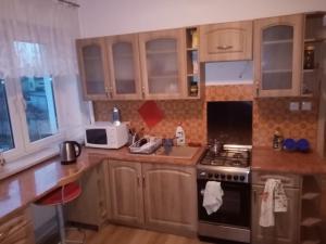 a kitchen with wooden cabinets and a stove top oven at Noclegi in Poznań