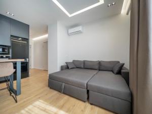 a living room with a couch and a kitchen at PIN Apartments in Tirana