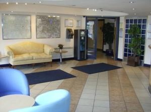 a lobby with a couch and a table and blue chairs at Diamond Lodge in Manchester