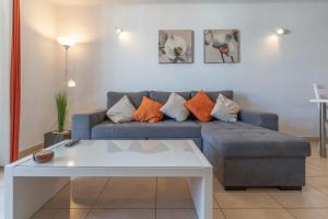 uma sala de estar com um sofá azul e uma mesa em GO2TENERIFE Apart'Valan Family Santiago 1 em Playa de las Americas