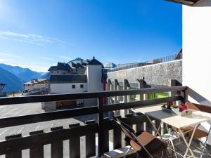a table and chairs on a balcony with a view of mountains at Appartement Saint-Lary-Soulan, 3 pièces, 7 personnes - FR-1-296-296 in Saint-Lary-Soulan
