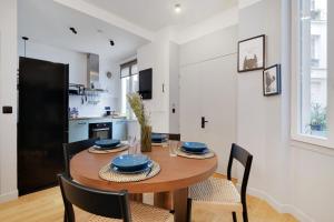 パリにあるBastille - Cosy design 1BR / 4P apartmentのキッチン、ダイニングルーム(木製のテーブルと椅子付)