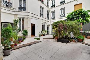 une cour d'un bâtiment avec des plantes en pot dans l'établissement Bastille - Cosy design 1BR / 4P apartment, à Paris