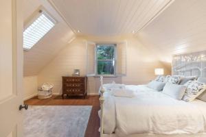 a bedroom with a white bed and a window at Carramar Estate: 2 homes stunning mountain views in Wentworth Falls