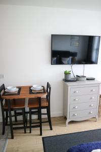 a dining room with a table and a tv on a wall at 12a Mault-Ley Studio in St Ives