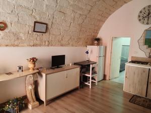 Habitación con escritorio, ordenador y nevera. en La Nicchia, en Ragusa