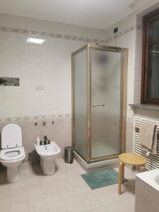 uma casa de banho com um chuveiro, um WC e um lavatório. em Luminoso e accogliente appartamento a San Donato em San Donato Milanese