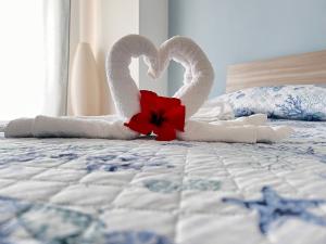 Dwa łabędzie na łóżku z kwiatem w obiekcie Special Home VISTA MARE e Parcheggio privato w San Remo