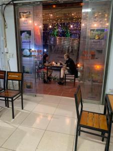 une femme assise à une table dans une pièce dans l'établissement Phuong Linh Hotel, à Bảo Lạc