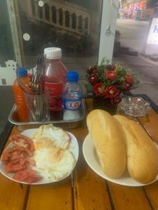 zwei Teller mit Frühstücksspeisen auf einem Holztisch in der Unterkunft Phuong Linh Hotel in Bảo Lạc