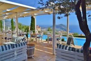 une terrasse avec une table, des chaises et une piscine dans l'établissement Belvedere, LaVanta, Kalkan, à Kalkan
