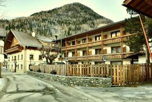 una recinzione di legno davanti a un edificio di das MARX - Gasthof Marx - Apartments a Grosskirchheim