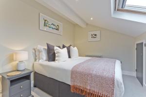 a bedroom with a large bed with white sheets and pillows at Sandgate Chapel - Self Check In Apartments in Penrith +41 photos
