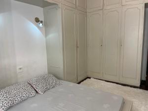 1 dormitorio blanco con 1 cama y armarios blancos en Quarto Camarim, en Río de Janeiro