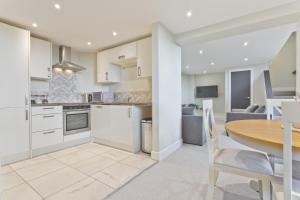 a kitchen and dining room with a wooden table at Sandgate Chapel - Self Check In Apartments in Penrith