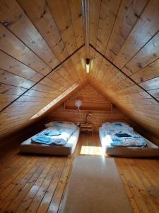 two beds in a room with a wooden ceiling at Chata Slapy - Ždáň in Slapy