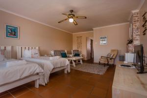 a bedroom with two beds and a flat screen tv at Saxon Lodge in Gansbaai +138 photos