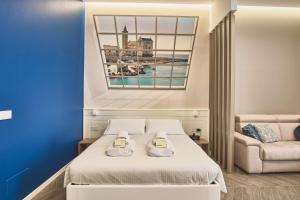 a bedroom with a bed and a couch at Michè luxury home - Appartamento vista mare a Trani in Trani