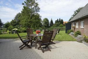 een houten tafel en stoelen met bloemen op een patio bij Hessener Esch in Dalfsen