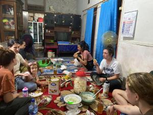 un gruppo di persone seduti sul pavimento che mangiano cibo di Adventure Turtle Homestay Meru Betiri a Sarungan