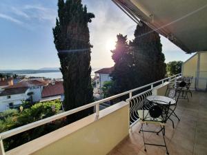 a balcony with chairs and a view of a city at Apartments Žic Malinska in Malinska