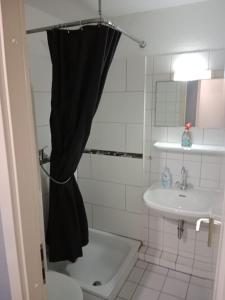 a bathroom with a black shower curtain and a sink at Stadtnah an der Förde 144 in Flensburg