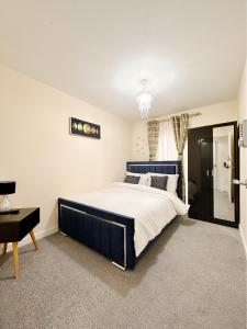 a bedroom with a large bed with a blue headboard at Luxury 2bed Apartment in Wolverhampton in Wolverhampton