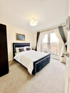a bedroom with a large bed and a large window at Luxury 2bed Apartment in Wolverhampton in Wolverhampton