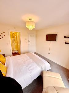 a bedroom with a large white bed and a couch at Luxury 2bed Apartment in Wolverhampton in Wolverhampton