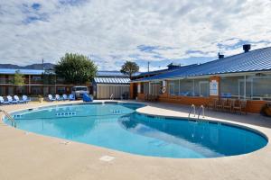a large swimming pool in front of a building at The Classic Desert Aire Hotel in Alamogordo