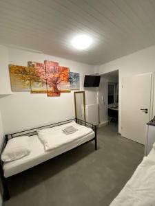 1 dormitorio con cama y pared blanca en 4-Jahreszeiten FeWo im Herzen Montabaur, en Montabaur