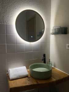 ein Badezimmer mit einem Waschbecken und einem großen Spiegel in der Unterkunft La petite halte in Lemberg