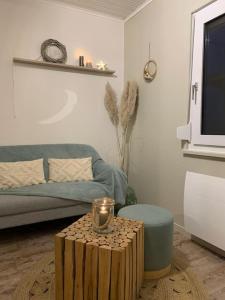 ein Wohnzimmer mit einem Sofa und einem Tisch mit einer Kerze in der Unterkunft La petite halte in Lemberg