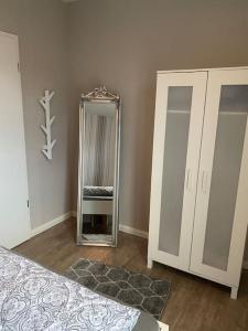 a bedroom with a mirror next to a closet at Schöne Ferienwohnung im Ergeschoss mit Terrasse in Ahaus +3 photos