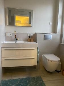 a bathroom with a white sink and a toilet at Schöne Ferienwohnung im Ergeschoss mit Terrasse in Ahaus