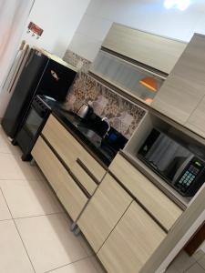 a kitchen with a stove and a microwave at Ocean Residence in Palhoça