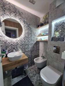 a bathroom with a sink and a toilet and a mirror at Апартамент Мегилукс 2 in Blagoevgrad