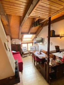 ein Wohnzimmer mit einem roten Sofa und einem Tisch in der Unterkunft La casa del Cucù al Ravascletto, 900mt from cable car in Zovello