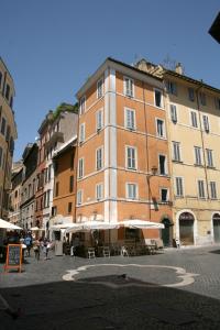 a tall building with tables and umbrellas in a street at Indimenticabili VACANZE ROMANE nel cuore della città in Rome