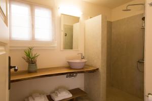 a bathroom with a sink and a mirror at Kapsaliana Village Hotel in Kapsalianá