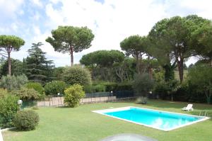 uma piscina num quintal com árvores em Vacanze Romane Olgiata em La Storta