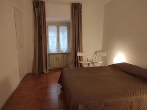 ein Schlafzimmer mit einem Bett, einem Fenster und einem Stuhl in der Unterkunft Locazione turistica di Via Ottaviano a Roma in Rom
