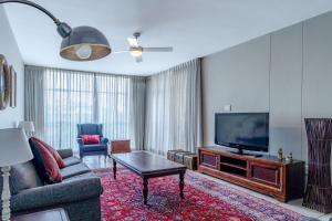 uma sala de estar com um sofá e uma televisão em Lovely 3 Bedroom apartment in the heart of Sandton 505 em Joanesburgo